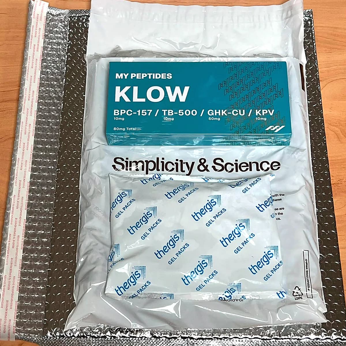 A product box and frozen gel pack sealed inside a wool-insulated envelope.